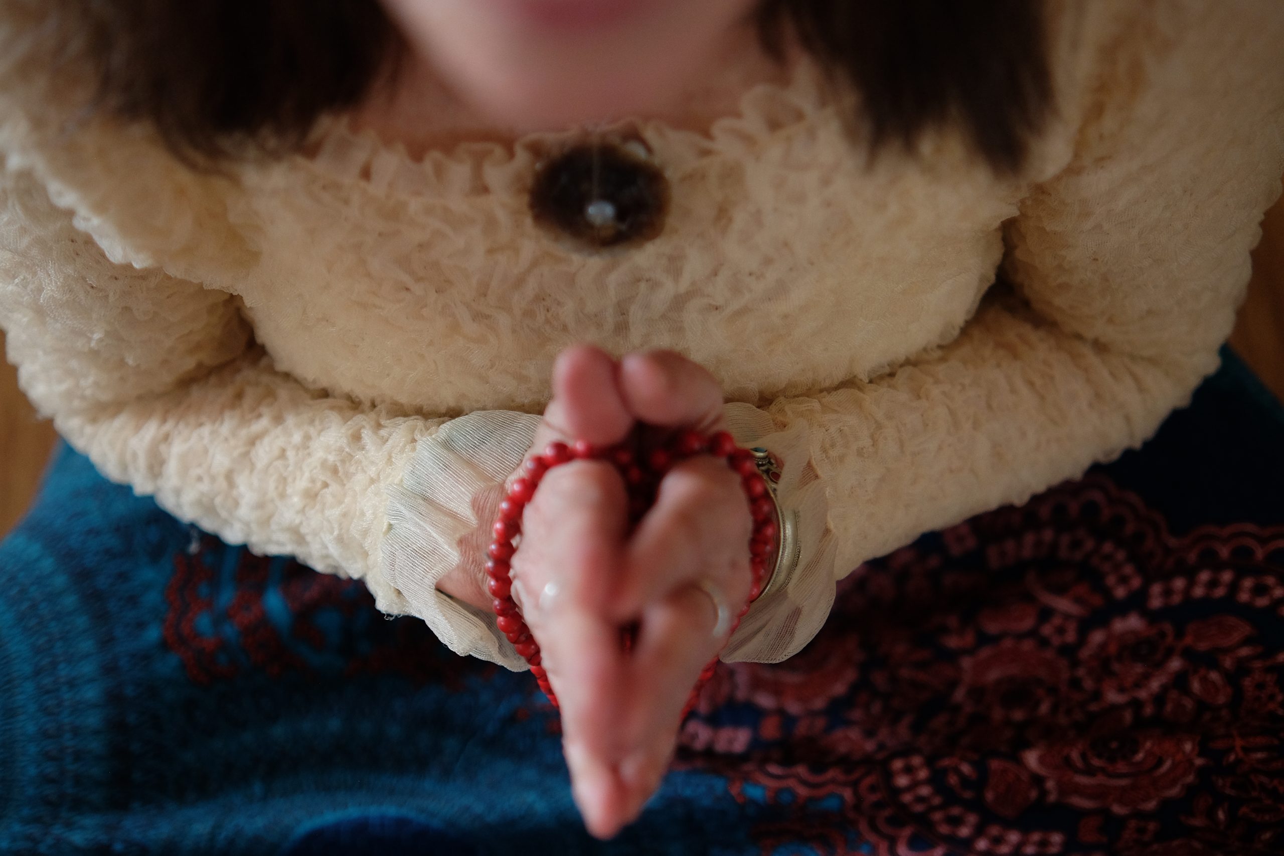Mains tenant un mala pendant une méditation